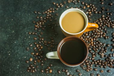 İki fincan kahve. Siyah arka planda iki farklı tat. Üst görünüm.