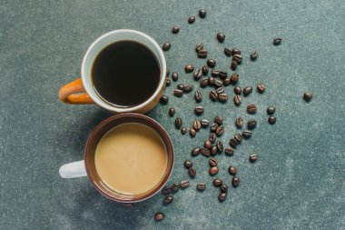 İki fincan kahve. Siyah arka planda iki farklı tat. Üst görünüm.