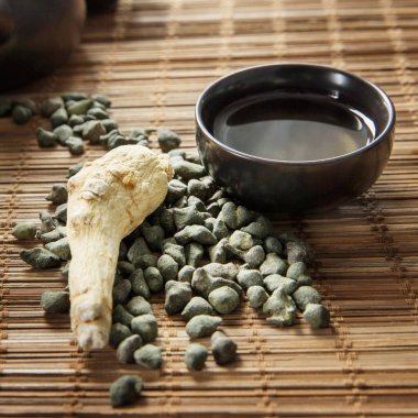 Ginseng çayı ve ginseng kökü. Ginseng Oolong çayı ve bir bardak ginseng oolong çayı..  