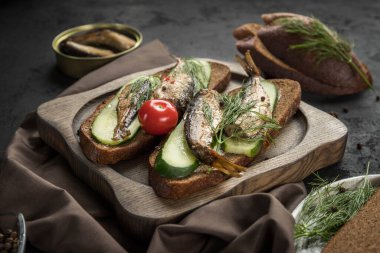 Ahşap sunucuda tütsülenmiş lahanalı sandviçler ve siyah arka plan. Sandviç.  .