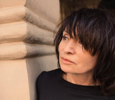 65 yaşında çekici bir esmer rüya gibi uzaklara bakıyor..