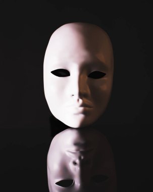 White mask, face with reflection on a black background. The concept of duality, mystery.
