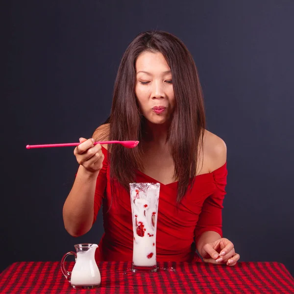 目を閉じたテーブルに座って イチゴとおいしいヨーグルトデザートを食べる美しい中高年アジアの女性 — ストック写真