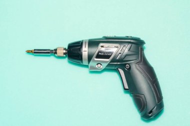 Mavi arka planda profesyonel tornavida. Pille çalışan yalıtımlı ev aletleri