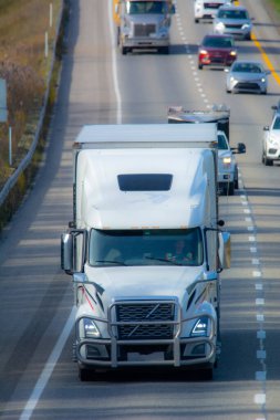 Arabalar asfalt yolda ilerliyor.