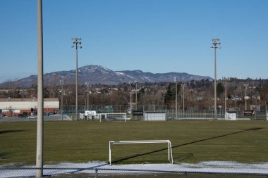 Arka planda dağlar olan futbol sahası manzarası