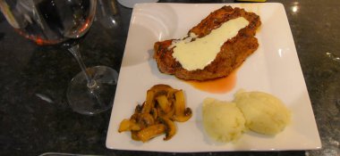 Şarap kadehi, soslu kızarmış et, mantar ve patates püresi fotoğrafı.