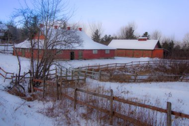 Terk edilmiş çiftlik binalarının karlı manzarası