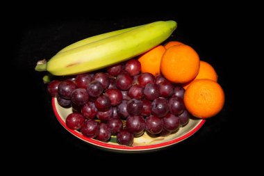 Sebze meyvesi. Siyah arka planda olgun meyve ve üzümler