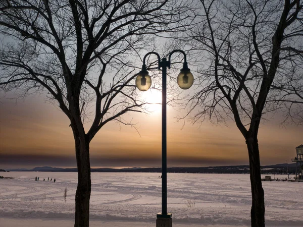 Poste Lâmpada Perto Lago Congelado Inverno Com Sol Começando Pôr — Fotografia de Stock