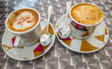 Beyaz arkaplanlı bir bardak kapuçino.