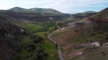 Köyün hava aracı görüntüleri ve dağ arasında inşa edilen yol, dağların arasındaki köye giden toprak yolun havadan çekilmiş görüntüsü.