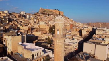 İnsansız hava aracı şehrin ortasında minarenin etrafında dönüyor, üstünde kuşlar olan eski minareler.