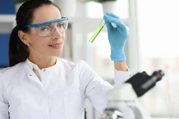 Πορτρέτο της χαμογελαστή γυναίκα επιστήμονας με γυαλιά που κατέχουν χημική σωλήνα δοκιμής στο εργαστήριο — Φωτογραφία Αρχείου