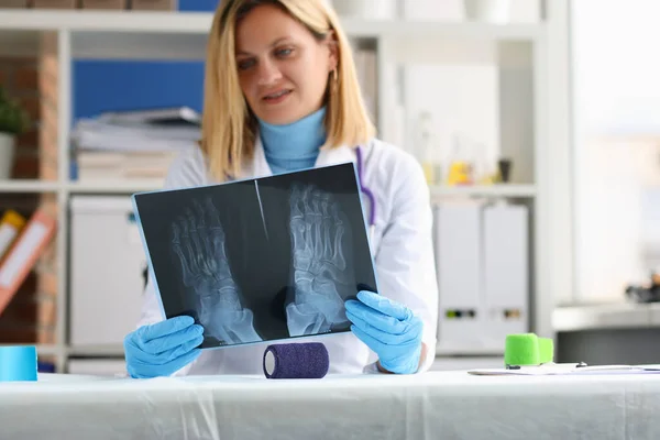 Ženský lékař vyšetřuje rentgen pacientovy nohy — Stock fotografie