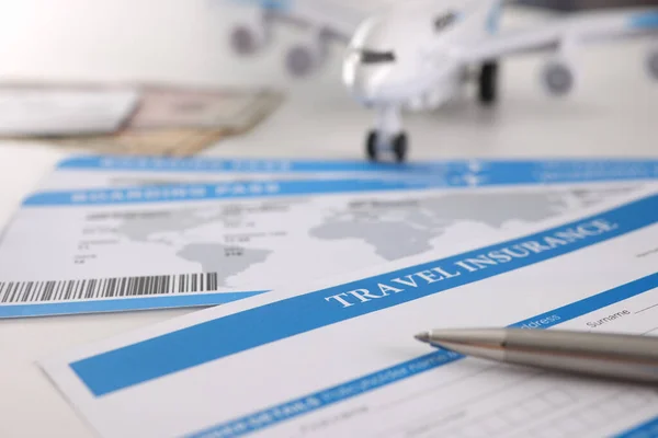 Umowa ubezpieczenia medycznego dla turystów pióro i samolot na stole — Zdjęcie stockowe