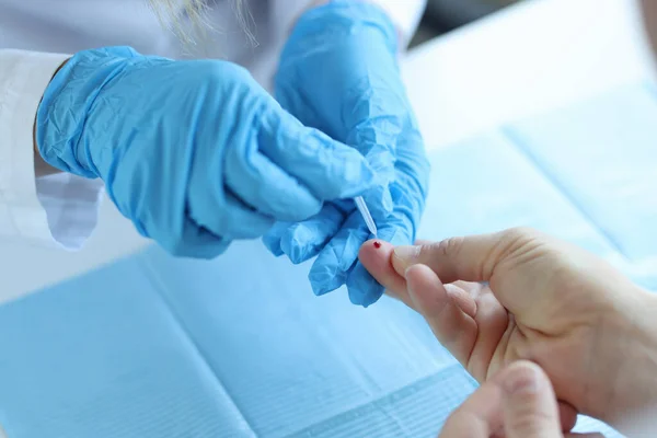 El médico que usa guantes desechables toma sangre del dedo del paciente —  Fotos de Stock