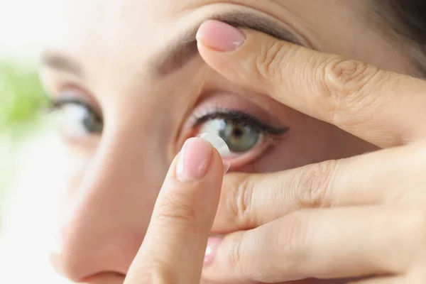 Kvinna sätter på mjuk kontaktlins över ögonen närbild — Stockfoto