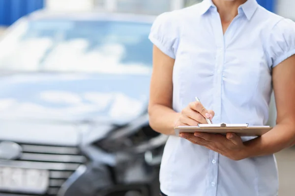 Silhouetten eines Versicherungsvertreters mit Klemmbrett und Stift auf dem Hintergrund eines kaputten Autos — Stockfoto