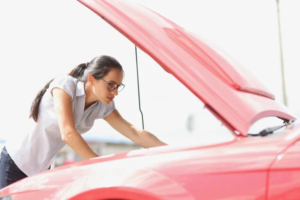 Εστιασμένη γυναίκα κοιτάζει αυτοκίνητο κινητήρα closeup — Φωτογραφία Αρχείου