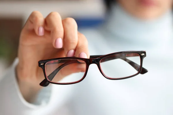 In female hand there are stylish fashionable glasses in black frames — Stock Photo, Image