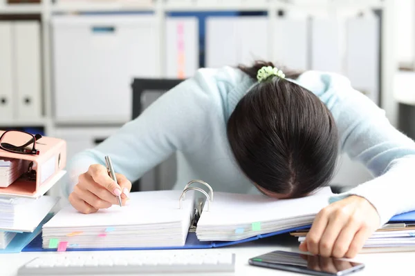 Trött kvinna ligger på mapp med dokument på bordet på kontoret — Stockfoto