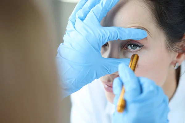 Dokter schijnt licht in het oog van de patiënt om pupil close-up te controleren — Stockfoto