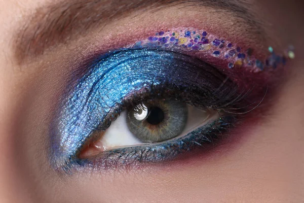 Bright blue evening eyelid makeup with multi-colored sparkles — Stock Photo, Image