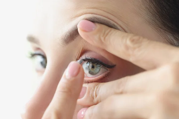 Vrouw zet op zachte contactlenzen close-up — Stockfoto