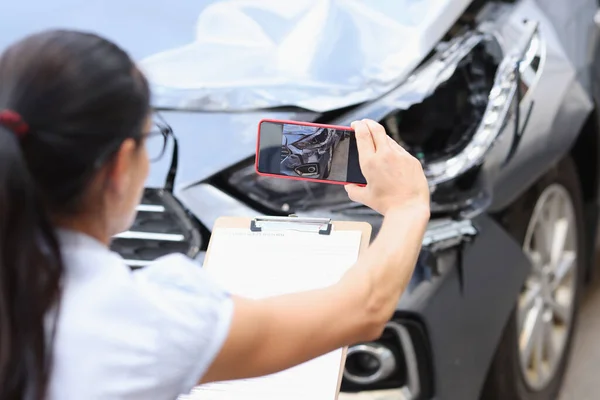Versicherungsvertreter fotografiert Schaden am Auto nach Unfall mit Smartphone — Stockfoto