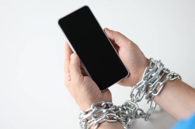 Zincirle sarılmış eller, siyah akıllı telefonu yakın plan tut.