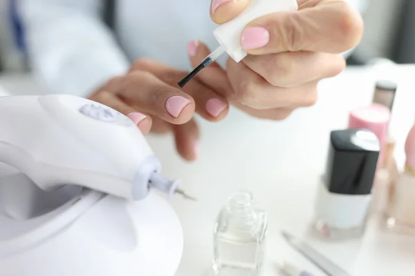 Vrouw doet haar eigen manicure met roze nagellak closeup — Stockfoto