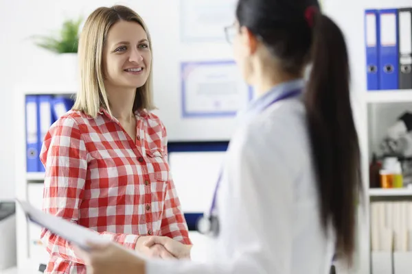 Woman patient shaking hands with doctor in clinic — Stock Photo, Image