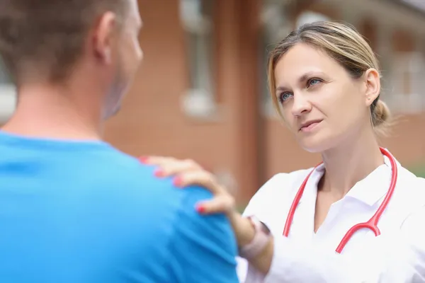 Женщина врач положить руку на плечо пациента, чтобы успокоиться — стоковое фото