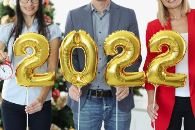 İş adamlarının elinde 2022 yılbaşı ağacının arkaplanındaki çalar saat numaraları var.