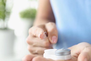 Kadın parmağı plastik kutudan kontak lensleri çekiyor.