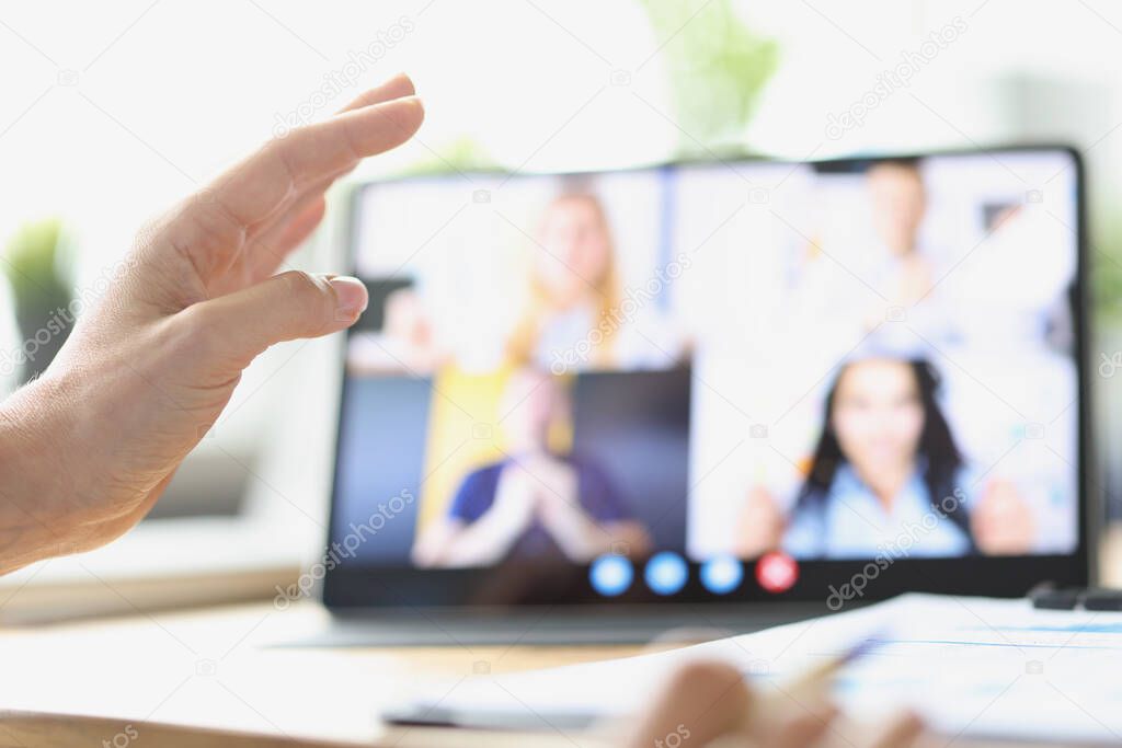 Female hand on background of tablet with video call from employees