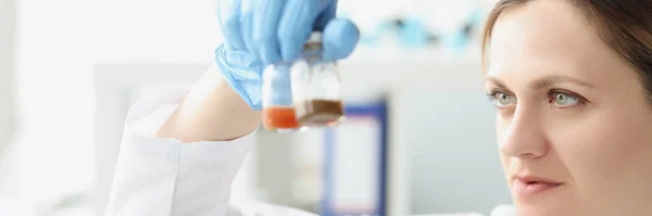 Femme scientifique chimiste tenant des bocaux en verre avec médecine devant le microscope — Photo