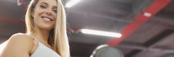 Jonge glimlachende sportvrouw tillen halter in de sportschool — Stockfoto