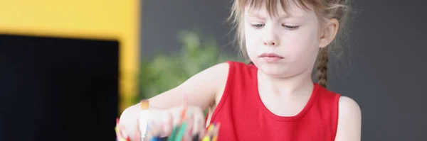 Kleines Mädchen nimmt Buntstift aus Container — Stockfoto