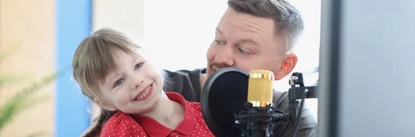 Pappa och dotter är engagerade i musik, det finns mikrofon i närheten — Stockfoto