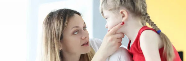 Лікар педіатр оглядає маленьку дівчинку горло крупним планом — стокове фото