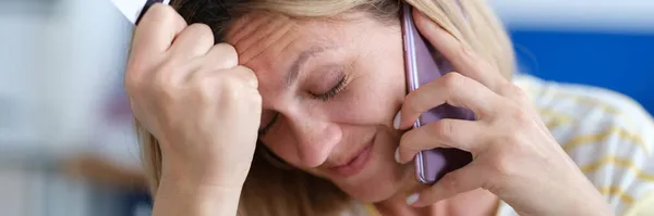 Donna sconvolta parlare al telefono e in possesso di carta di credito di plastica — Foto Stock