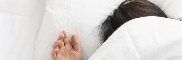 Vrouw liggend in bed onder witte deken in slaapkamer — Stockfoto