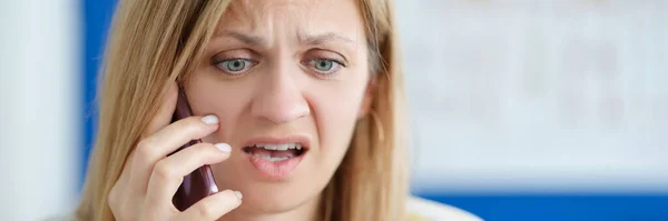 Surprised upset woman talking on mobile phone and holding bank card — Stock Photo, Image