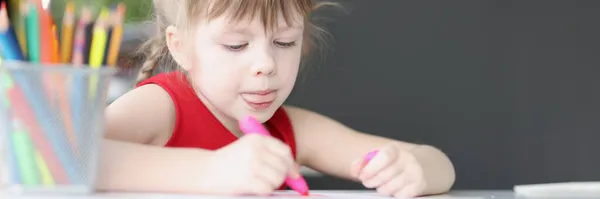 Küçük kız evde renkli kalemlerle resim çiziyor. — Stok fotoğraf