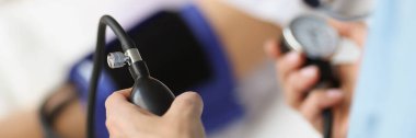 Hastanedeki hastanın tansiyonunu ölçmek için tonometre kullanan doktor.