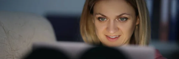 Portret van een vrouw in het donker kijkt naar scherm van de tablet — Stockfoto