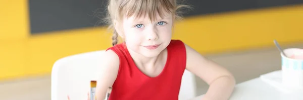 Little girl draws with colored pencils on paper closeup — Stock Photo, Image