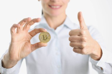 Altın Bitcoin ve kadın elinde baş parmak.